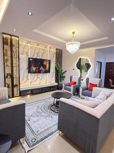 a large living room with couches and a tv at Hapton apartment in Abuja