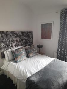 een slaapkamer met een wit bed en een hoofdeinde bij Terrace cottage in Blackpool