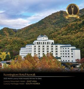 a large white building in front of a mountain at KensingtonHotel Seorak in Sokcho