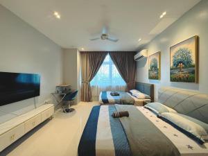 a bedroom with two beds and a flat screen tv at Riverine Cozzy Resort RDA in Kuching