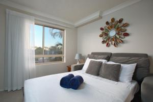 a bedroom with a bed with a blue hat on it at Bila Vista Kirra Beachside Apartments in Gold Coast +42 photos