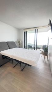 un grande letto in una camera con divano di Departamento Concon Costa de Montemar a Concón