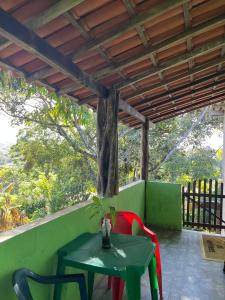 a green table and chairs on a porch at CANTINHO do SILENCIO in Morro de São Paulo