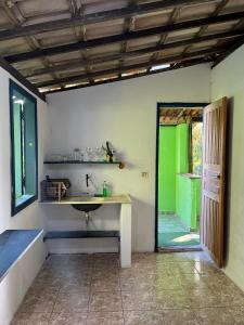 a bathroom with a sink and a green door at CANTINHO do SILENCIO in Morro de São Paulo