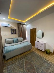 Un dormitorio con una cama grande y un espejo. en Cozy home wuye, en Abuja