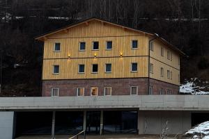 un grand bâtiment en bois avec des fenêtres sur un pont dans l'établissement Timber Studio - Schladming, à Schladming