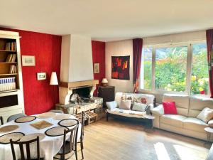 sala de estar con sofá, mesa y chimenea en Villa arborée aux Portes de Paris proche Stade de France, Zenith, Le Bourget, CDG, Parc Asterix, en Bobigny