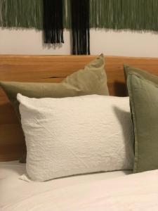 een wit kussen op een bed met groene kussens bij Pet Friendly Acer Arena Accommodation in Sydney