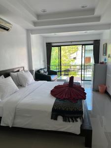 a bedroom with a large bed with a large window at The Seashore Kamala Service Apartment in Kamala Beach