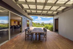 comedor con mesa y sillas en la terraza en Lookout Landing by Waiheke Pure, en Waiheke Island