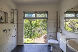 Un baño con inodoro, lavabo y ventana. en Lookout Landing by Waiheke Pure, en Waiheke Island 35 fotos más