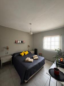 una camera da letto con un letto grande con cuscini gialli di Casa Serena Rio a Viedma