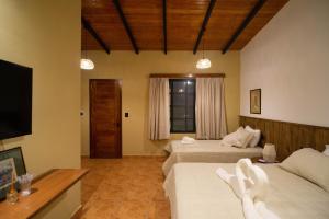 a hotel room with two beds and a television at San Cosme y Damian Lodge & Spa in San Cosme y Damián +47 photos