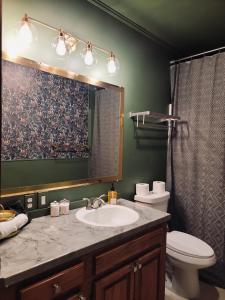 um banheiro com uma pia, um vaso sanitário e um espelho em The Starling Room at Stag and Sparrow em Salem