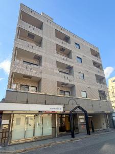 un palazzo alto in una strada di città con un edificio di OUCHI HOTEL Tokaichi a Hiroshima