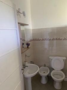 a bathroom with a toilet and a sink at La Camelia in Juan L. Lacaze +8 photos