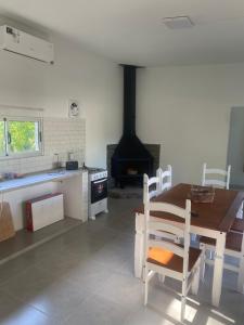 a kitchen and dining room with a table and a fireplace at La Camelia in Juan L. Lacaze