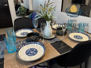 a table with blue and white plates and wine glasses at The Gilded Blue Nest in Mandaue City