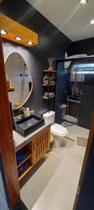 een badkamer met een wastafel, een toilet en een spiegel bij Natureza in Porto Seguro