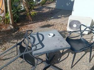 uma mesa, duas cadeiras e um ventilador na calçada em Mackay Oceanside Central Hotel Official em Mackay