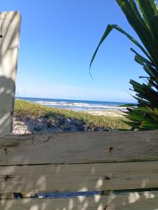 a view of the beach from a wooden fence at Chalé pé na areia e vista Mar in Ilhéus