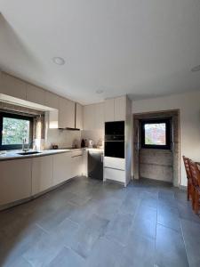 eine Küche mit weißen Schränken und einem Fliesenboden in der Unterkunft Quinta dos Carvalhos in Cabana Maior + 11 Fotos