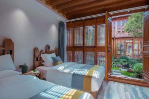 En eller flere senge i et værelse på LiJiang Sunshine Garden Villa