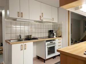 Ramsöにある5 star holiday home in VAXHOLMのキッチン(白いキャビネット、シンク、コンロ付)