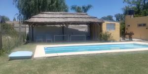 a gazebo with a swimming pool in a yard at Lo de Benja in Agote