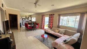 a living room with a couch and a dining room at Recanto Maria de Souza in Caçapava