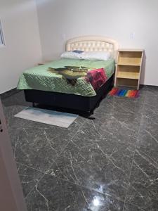 a bedroom with a bed and a tiled floor at AP BEIRA MAR 01 QUARTo in Jaguaruna