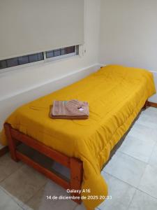 - un lit avec une couverture jaune au-dessus dans l'établissement Dpto Céntrico con Asador, à Chilecito