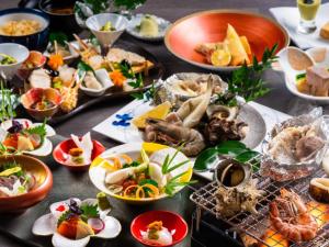 a table with many plates of food on it at KAMENOI HOTEL Genkainada in Kitakyushu