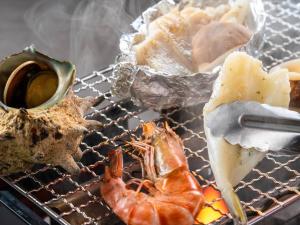 a grill with a shrimp and other foods on it at KAMENOI HOTEL Genkainada in Kitakyushu