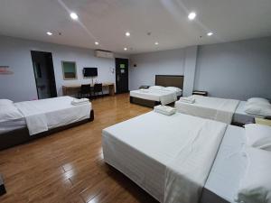 a room with three beds and a flat screen tv at Asia Jem Hotel - Bacolod City in Bacolod