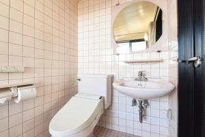 ein weißes Badezimmer mit Toilette und Waschbecken in der Unterkunft サンシティーホテル山代 in Kaga + 34 Fotos