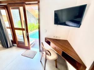 ein Zimmer mit einem Schreibtisch mit Fernseher und einem Stuhl in der Unterkunft Villa Leyan 1 Semer - Between Seminyak & Canggu in Seminyak