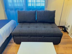 un soggiorno con un divano e un tavolo di OUCHI HOTEL Tokaichi a Hiroshima