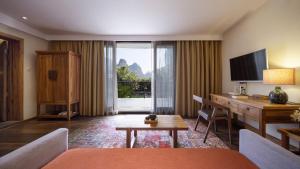 a hotel room with a desk and a computer in it at Yangshuo The Apsara Lodge in Yangshuo