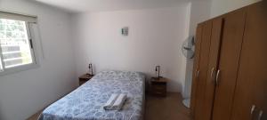 ein kleines Schlafzimmer mit einem Bett und einem Fenster in der Unterkunft Complejo Solares in Villa Carlos Paz