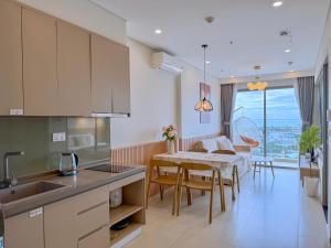 ViVi's Home - The Sóng Apartment Vũng Tàu في فنغ تاو: مطبخ وغرفة طعام مع طاولة وكراسي