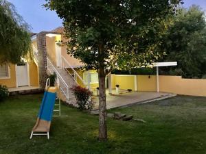ein Baum mit einer blauen Rutsche im Garten in der Unterkunft Complejo Solares in Villa Carlos Paz