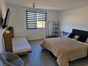 um quarto com uma cama, uma cadeira e uma janela em Entre Quebradas y Loicas em Algarrobo