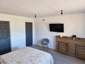 um quarto com uma cama e uma televisão na parede em Entre Quebradas y Loicas em Algarrobo