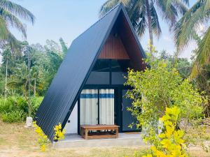 uma pequena casa com um banco na frente em The Banana Cottage em Udawalawe