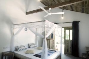 una camera con letto bianco e ventilatore a soffitto di Solara Arugam Bay ad Arugam