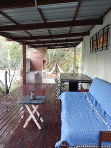 a room with a bed and a table on a deck at Tu lugar de relax a 2 cuadras de la playa Se reserva con seña in Guazuvira