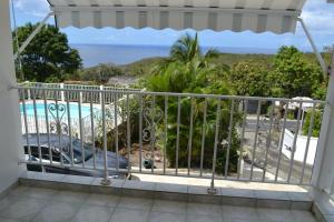 a balcony with a view of a pool at La Nicotoria HAUT DE VILLA T4 in Deshaies