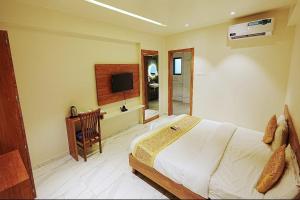 a bedroom with a bed and a television in it at LP Regency in Pune