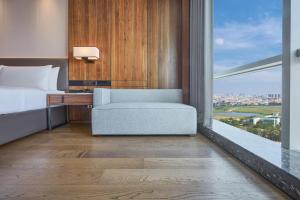 a bedroom with a bed and a desk and a window at Crowne Plaza Phnom Penh by IHG in Phnom Penh